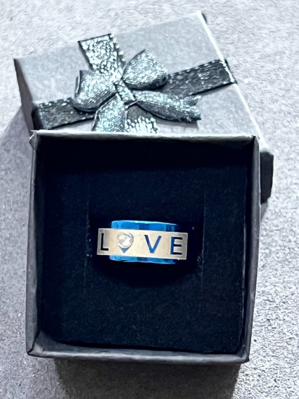 Modern blue and silver-tone statement ring featuring a bold “LOVE” design with a